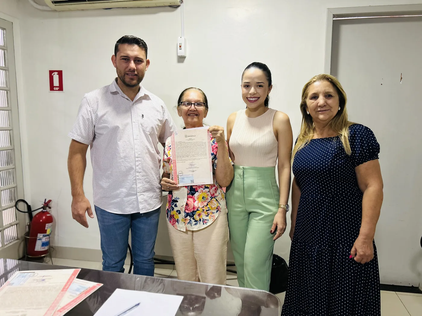 Família com o título de regularização fundiária em mãos