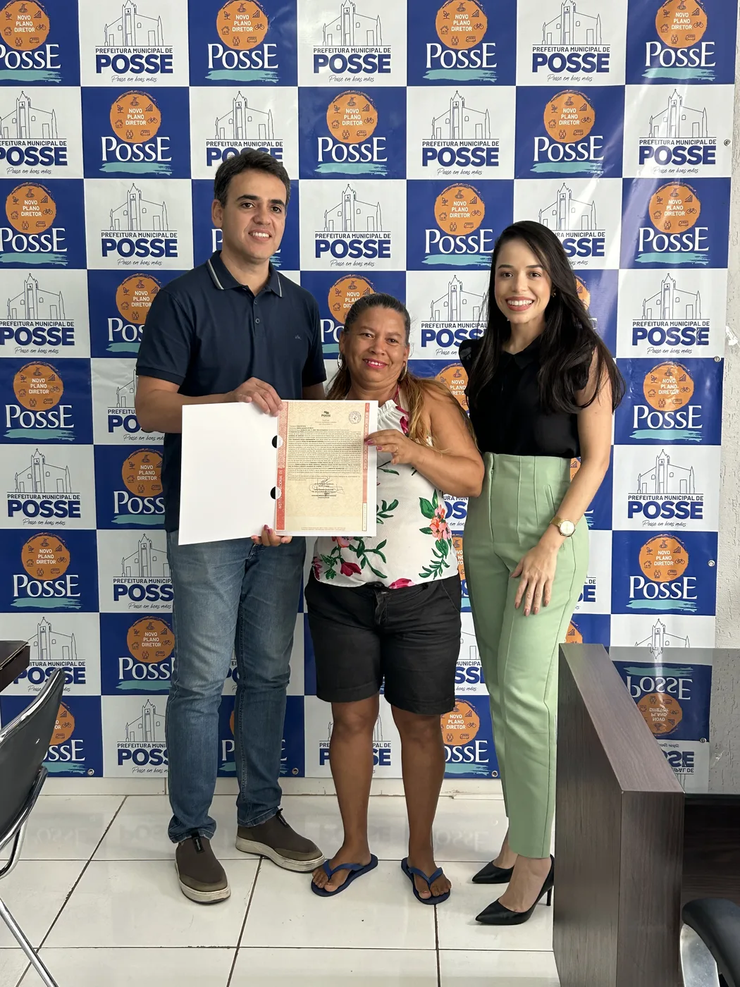 Cliente recebendo título em evento oficial da prefeitura