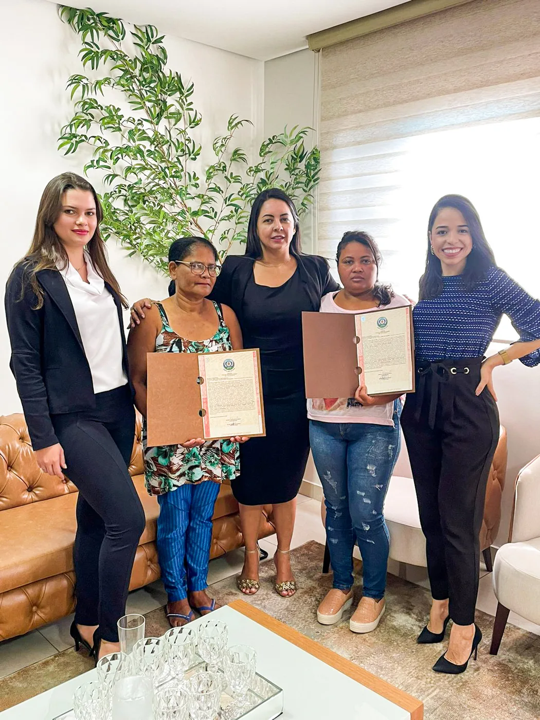 Duas famílias recebendo seus títulos de REURB juntas