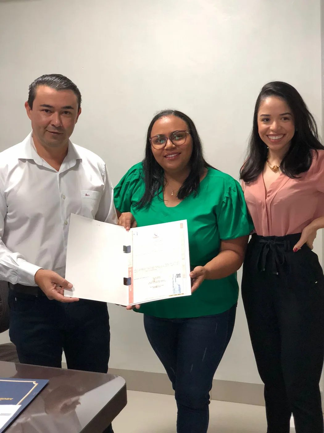 Cliente recebendo o título de regularização fundiária